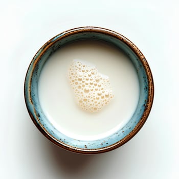 Milk in cup isolated on white background with shadow. Milk in blue cup full of calcium top view photo