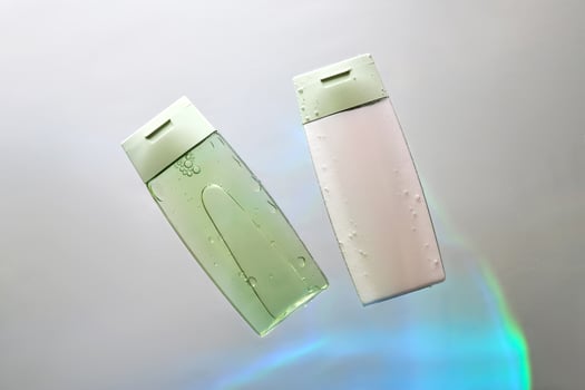 Shampoo and hair conditioner in water on a white background with colored light. photo