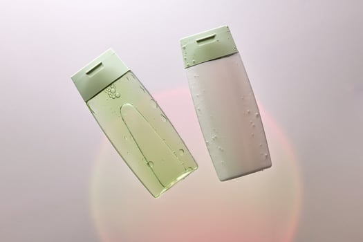 Shampoo and hair conditioner in water on a white background with colored light. photo