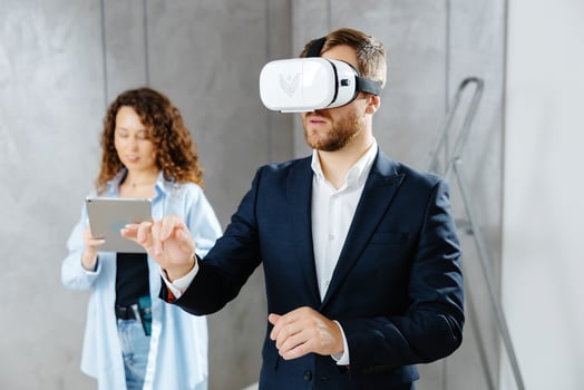 Man client wearing VR glasses imagining future interior standing with designer at the construction site. The concept of repair on a modern design. photo