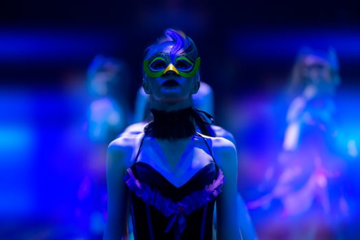 A girl dances in a show or circus in the blue rays of stage lighting. Theatrical performance. photo