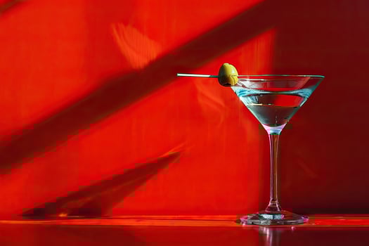 Martini glass with olive on red background. photo