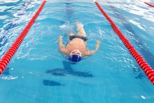 A pensioner of 70 years rests and swims in the pool in a clean, blue pool in the fresh air on vacation. photo
