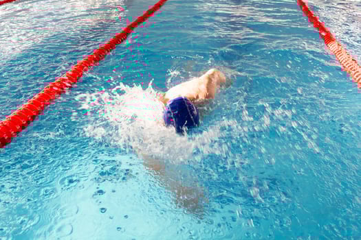 A pensioner of 70 years rests and swims in the pool in a clean, blue pool in the fresh air on vacation. photo