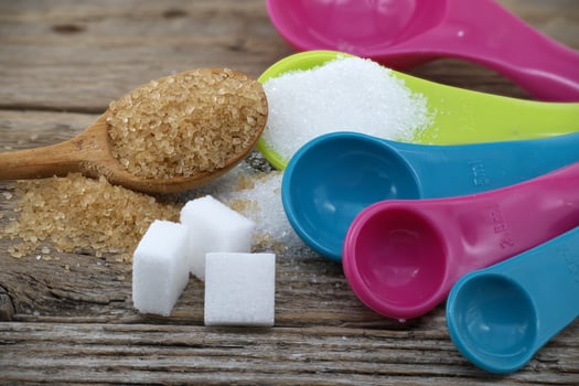 Measuring utensils and spilled sugar on rustic wood photo