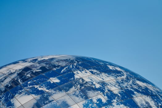 Earth planet modern building with clouds and blue sky, ecological architectural concept photo