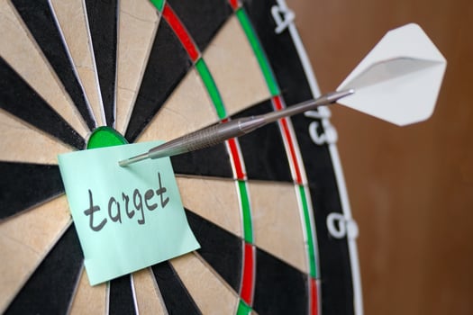 Dart hit the centre of target and attaches sticker with inscriptions target photo