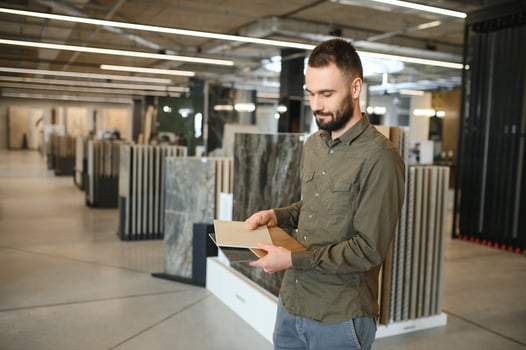Handsome man customer choosing ceramic tile at building materials store photo