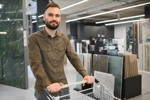 Confident male customer picking out wall tile materials for bathroom in hardware store photo