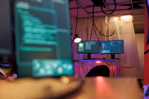 Computer screens with malware running code stealing sensitive information in hackers abandoned warehouse. Malicious software with internet virus on monitors in dark hideout with neon light photo