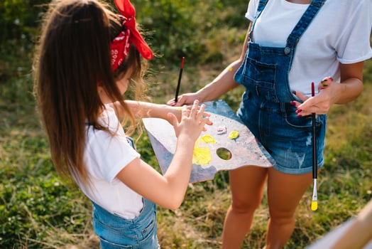 Beautiful mother with daughter. Family in a summer park. Little girl drawing photo