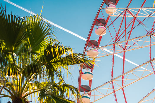 View of the Ferris wheel attraction against a background of blue sky between palm trees. Ferris wheel in the Georgian city of Batumi. photo