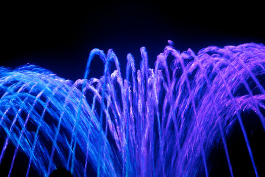 Coloured water fountain at night photo