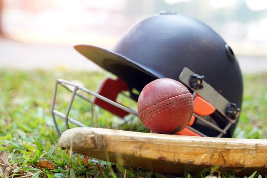 Cricket equipment is a cricket ball, cricket bat, cricket helmet on a grass background. Soft and selective focus. photo