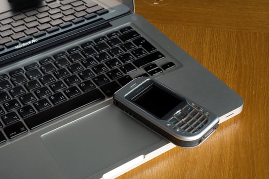 Phone, laptop and empty notebook on the desk photo
