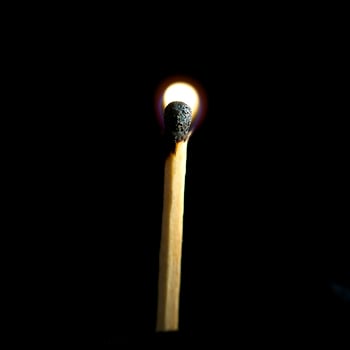 Wooden match burning on a black background photo