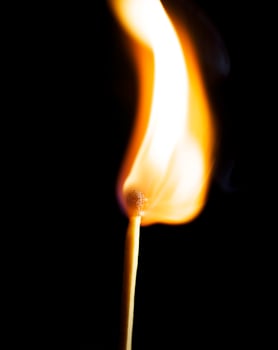 Wooden match burning on a black background photo