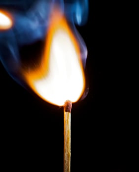 Wooden match burning on a black background photo
