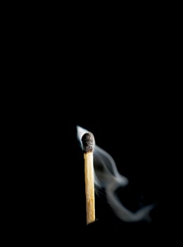Wooden match burning on a black background photo