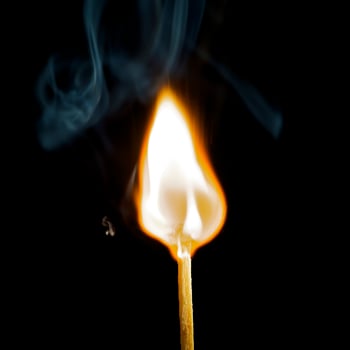 Wooden match burning on a black background photo
