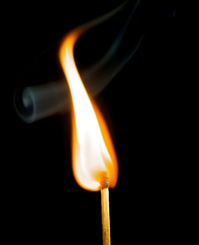Wooden match burning on a black background photo