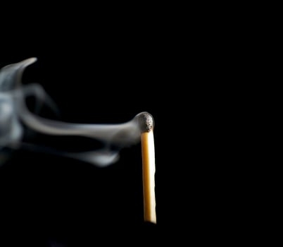 Wooden match burning on a black background photo