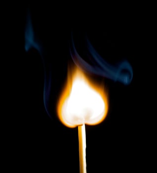Wooden match burning on a black background photo