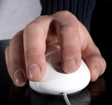 The man's hand works with the white mouse photo