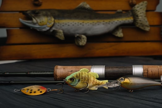 Fishing tackle - fishing spinning, hooks and lures on darken wooden background. Top view photo