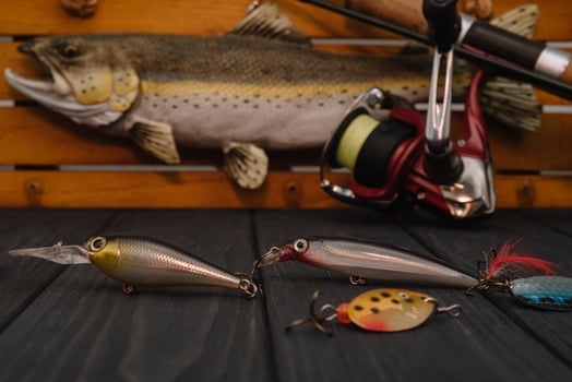 Fishing tackle - fishing spinning, hooks and lures on darken wooden background. Top view photo