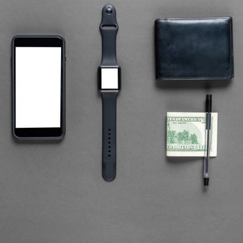 Business concept. Top view of dollars, watch, smartphone on color background photo