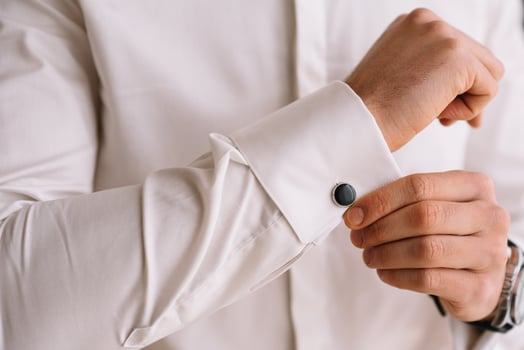 Groom's morning. Wedding preparing. Man in white shirt putting on cufflinks. Business dress code. photo