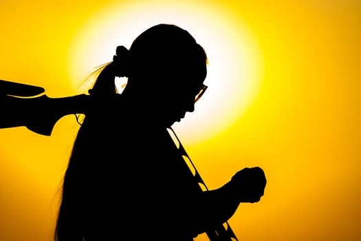 Silhouette of people with guns at sunset photo