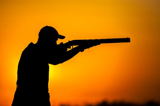 A man is silhouetted in front of a sunset photo