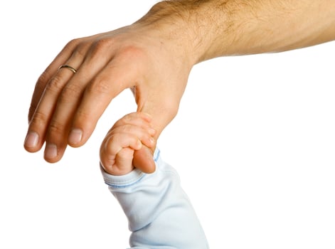 A baby's hand holds the father's hand. photo