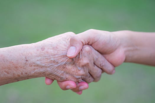 Hands of a senior woman holding the hand of a young woman. Encouragement concept photo