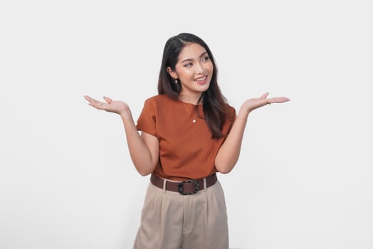Happy Asian woman is smiling and presenting the copy space beside her over isolated white background. photo