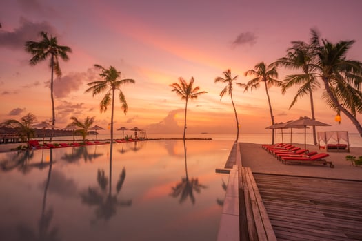 Outdoor luxury sunset over infinity pool swimming summer beachfront hotel resort, tropical landscape. Beautiful tranquil beach holiday vacation background. Amazing island sunset beach view, palm trees photo