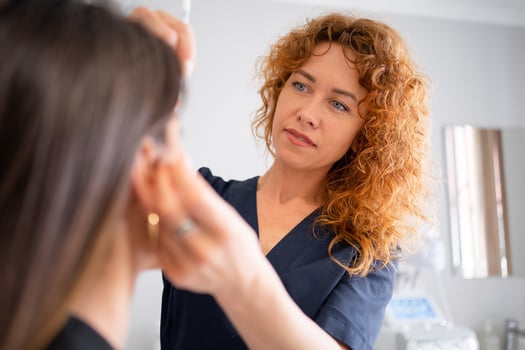 Dermatologist performing procedure on woman customer at clinic photo