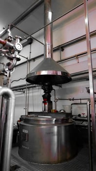 A large metal machine with pipes and valves, sitting on a metal platform. photo