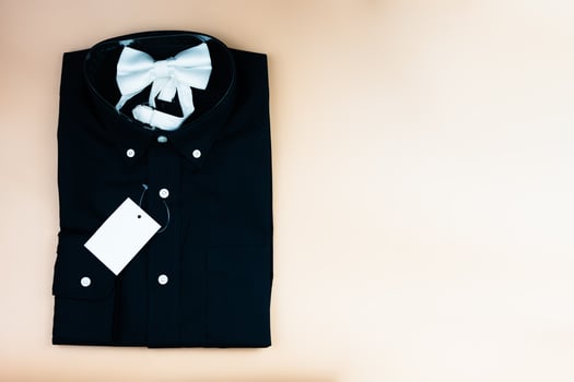 Black folded mens shirt with blank tag label mockup and white bow tie photo