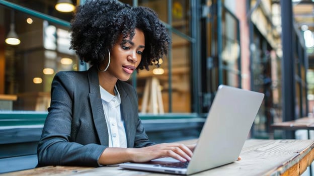 Attractive young woman in formal suit, using laptop computer having conversation on call photo