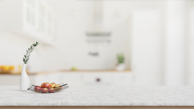 A close-up shot of a white marble kitchen tabletop with empty space in a modern white kitchen. photo