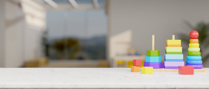 Colorful kid toys on a white table with a blurred background of a modern living room or class room. photo