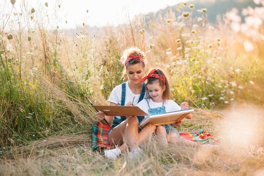 Sunny nature, mom and daughter paint a picture in a park , painting a Little Child, Child Creativity. Mother's Day. photo