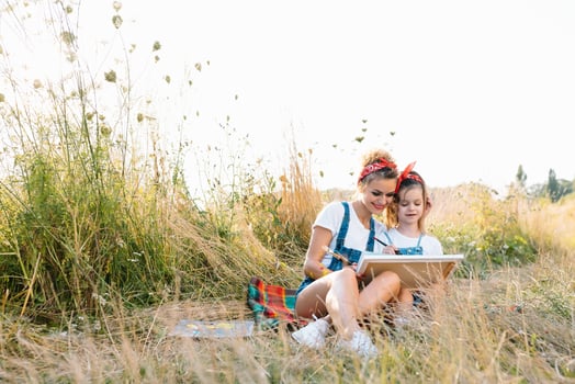 mother teaches daughter paint in park. Sunny nature, mom and daughter paint a picture in a park , painting a Little Child, Child Creativity. Mother's Day. photo