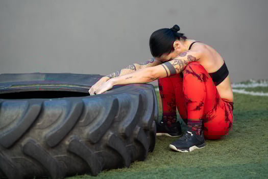 Tired mature sportive woman training with wheel in a gym photo