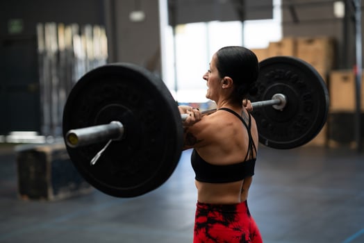 Strong mature woman lifting weights in a gym photo