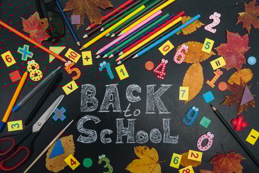 Back to school concept. School and office supplies on blackboard background photo