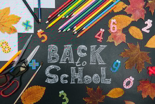 Back to school concept. School and office supplies on blackboard background photo